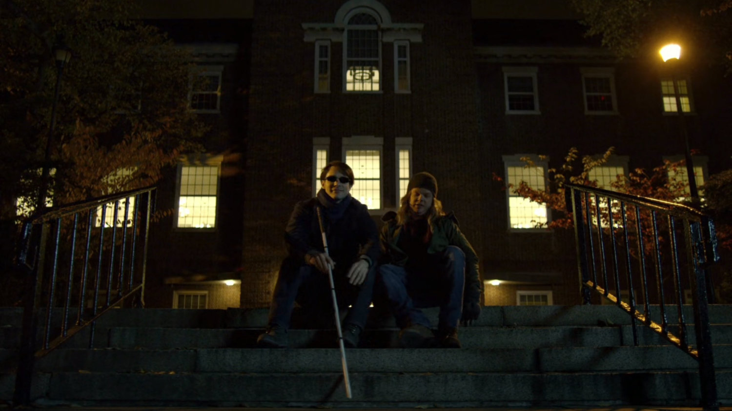 College-aged Matt and Foggy in college quad at night.
