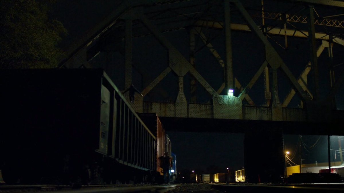 Matt leaps from train car onto man at night.