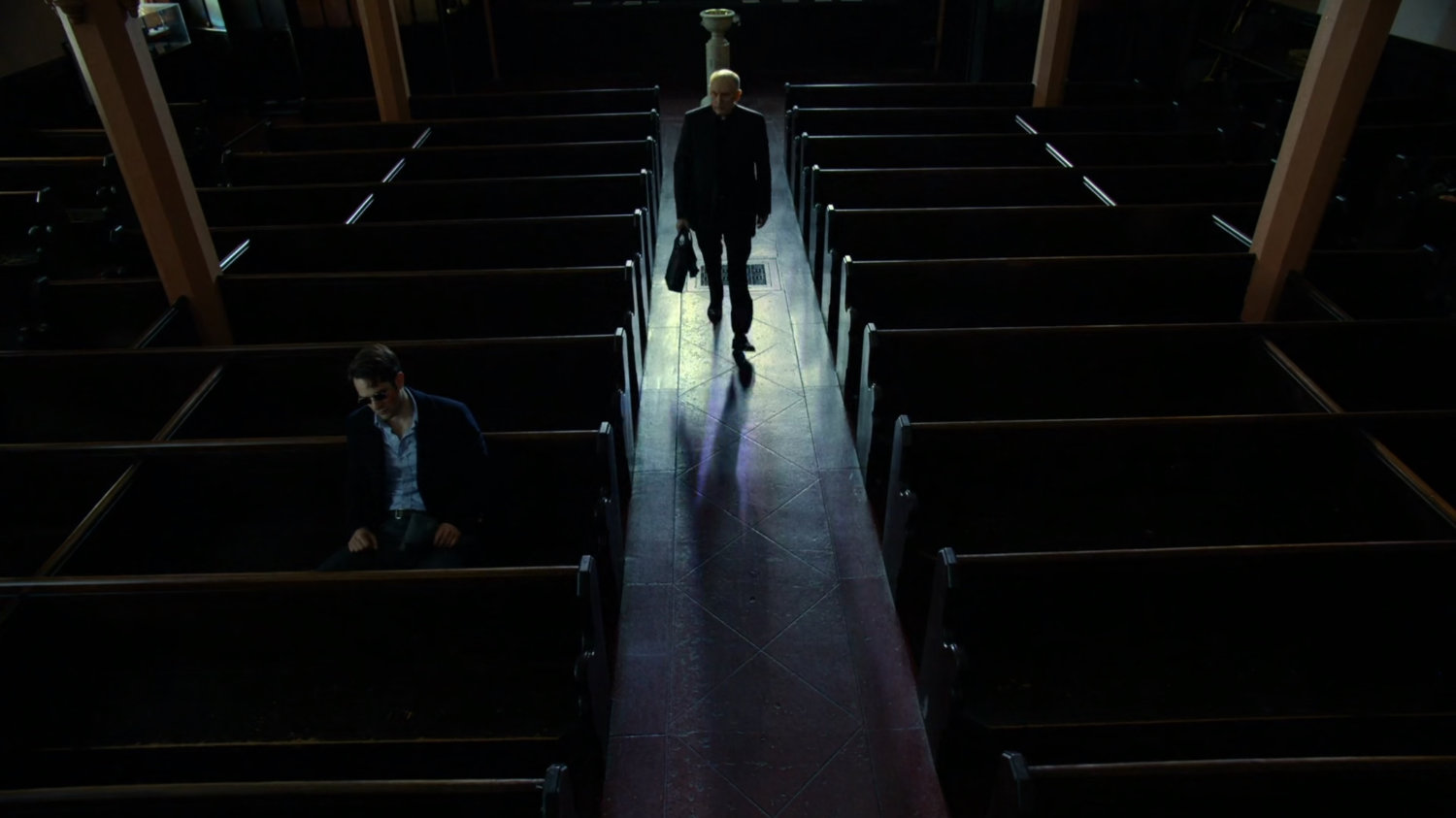 Matt and Father Lantom in church pews.