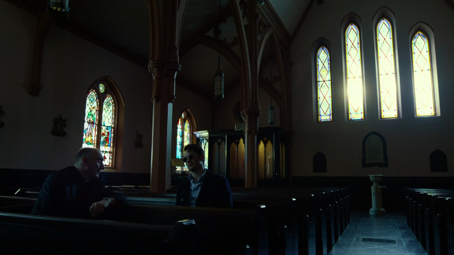 Matt and Father Lantom in church pews.