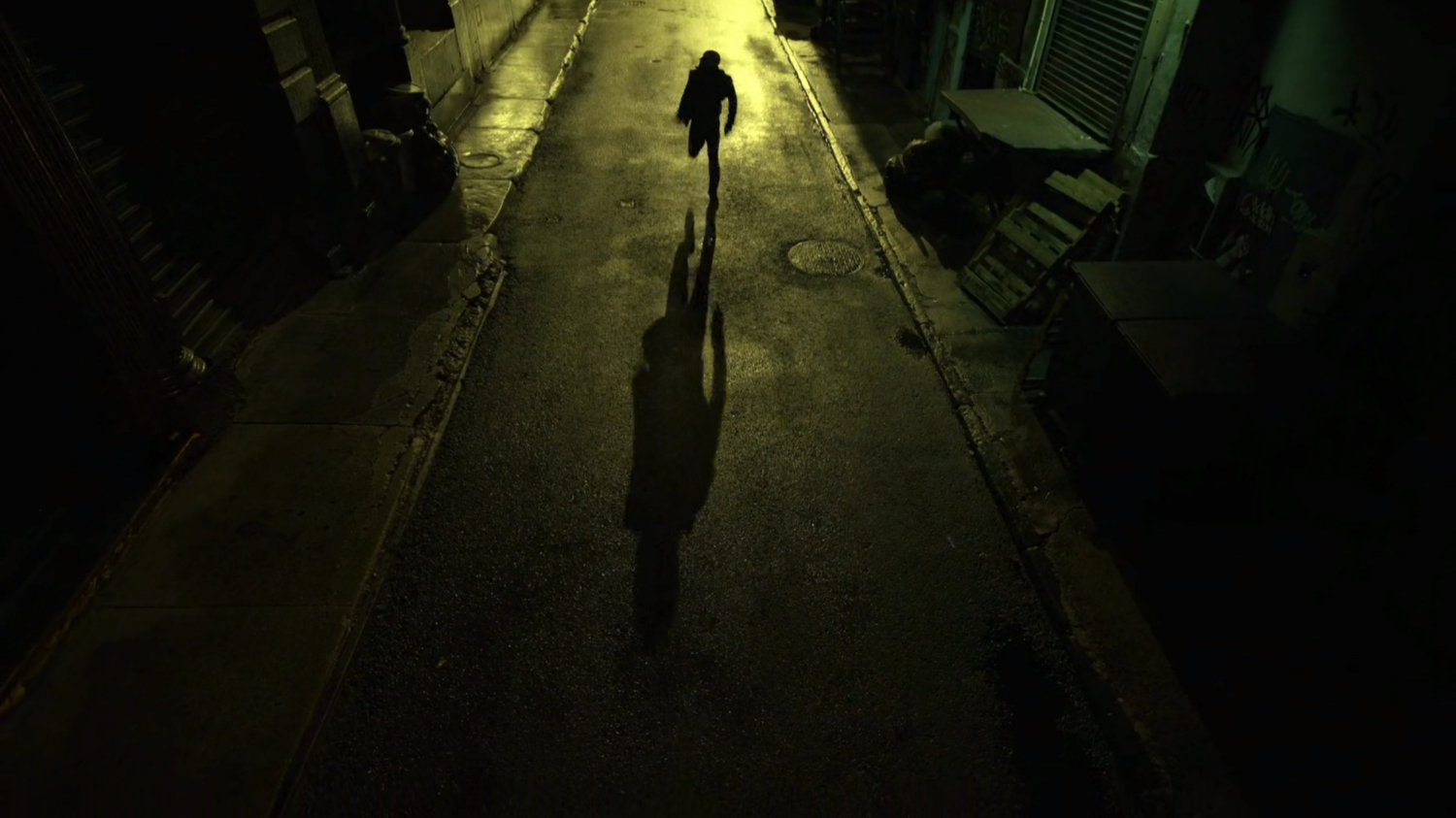 Turk running through a dark alley.
