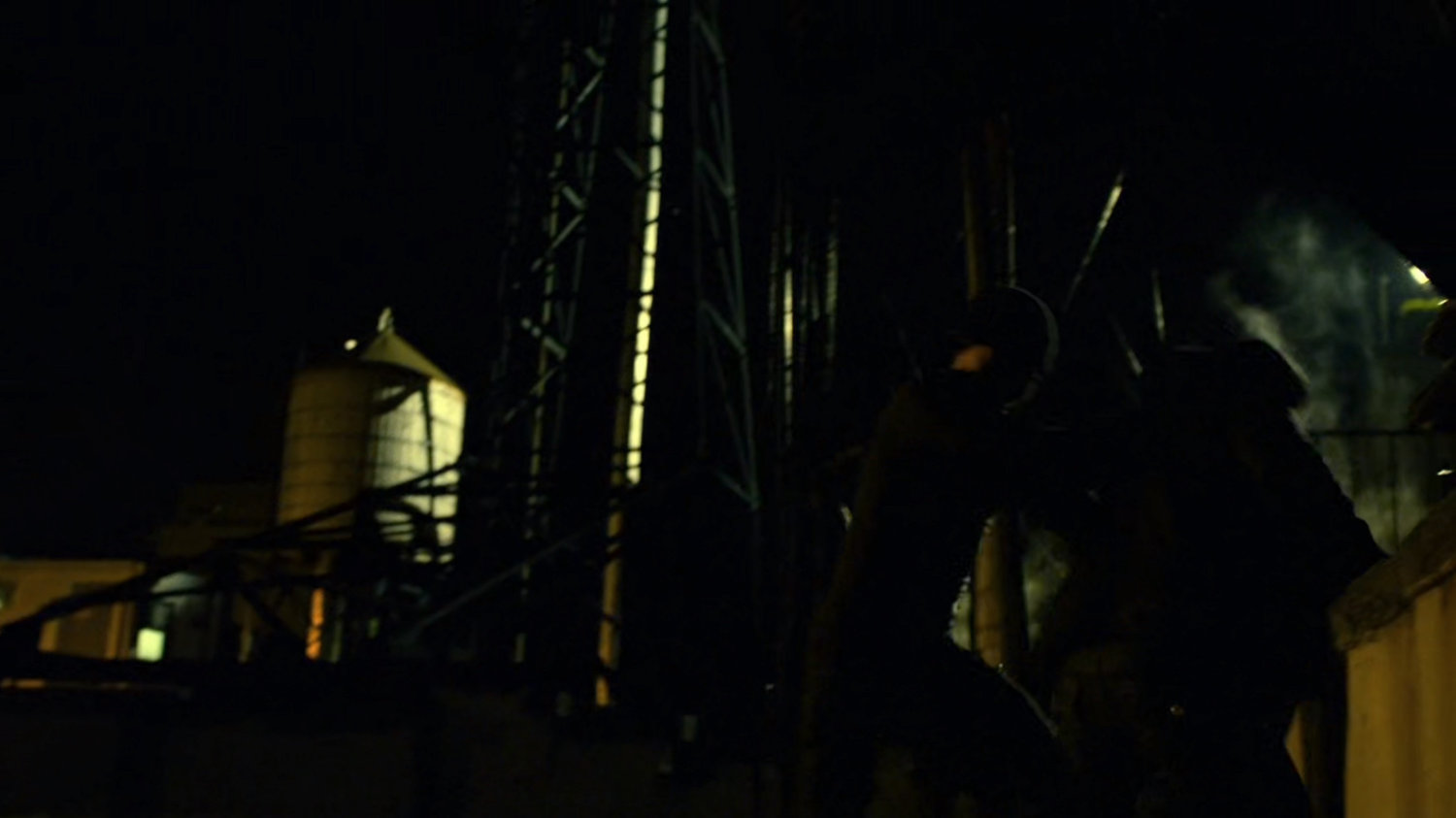 The Man in Black and Turk on a dark rooftop.