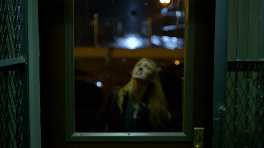 Karen outside her front door at night.