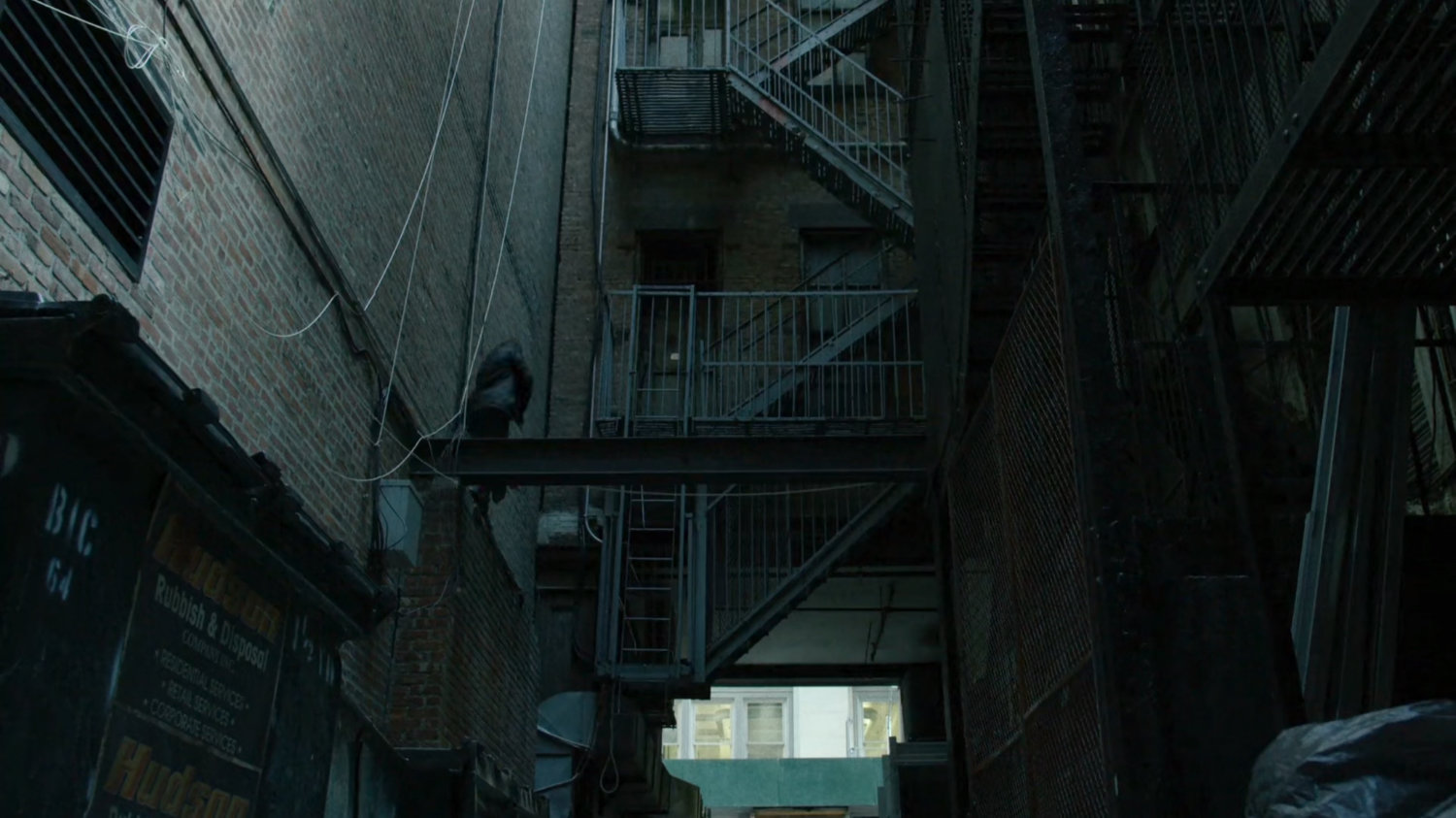 Matt climbs scaffolding in alley.