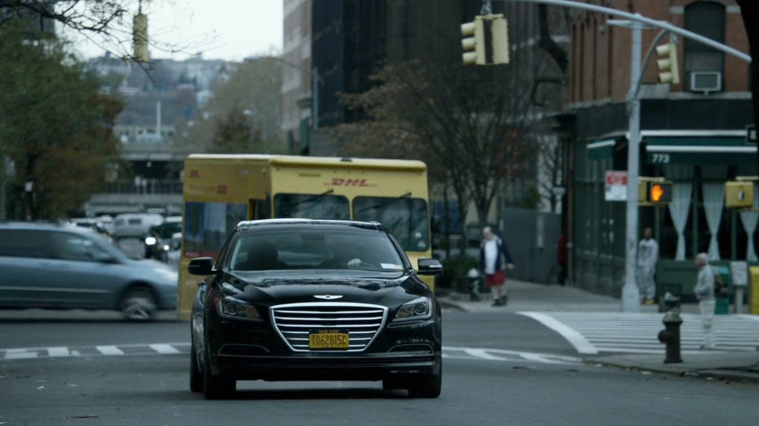 A black sedan drives up a New York street.