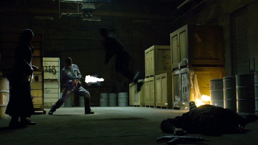 The man in black fights thugs inside Gao's warehouse.