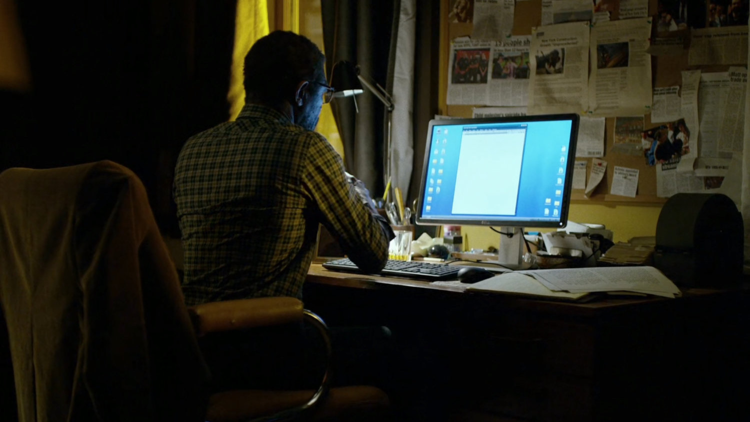 Ben at his computer inside his apartment.