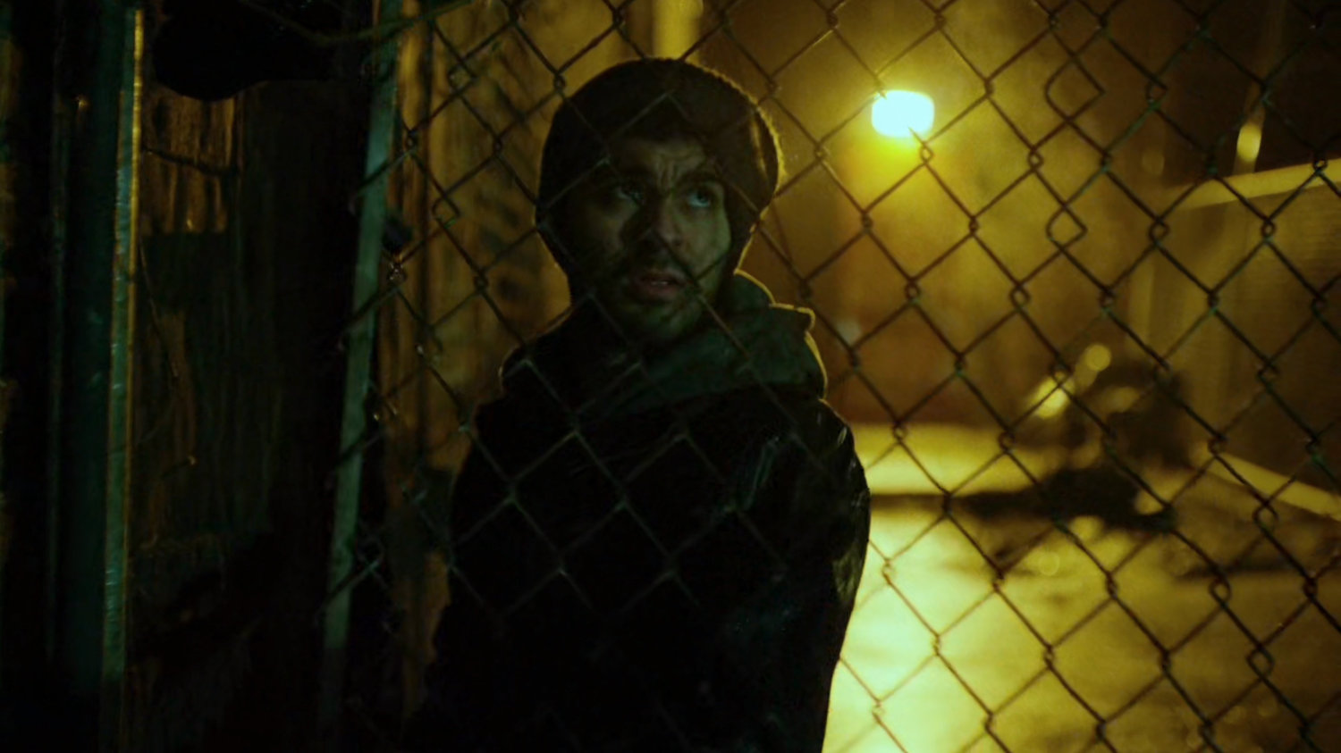 Man in dark alley behind abandoned theater.