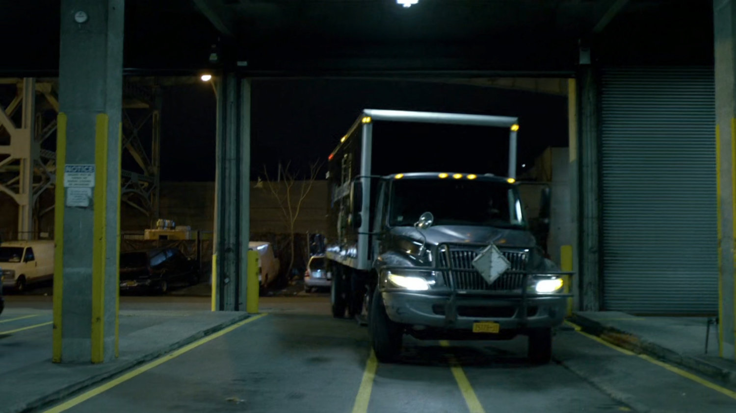A moving truck pulling into a garage.