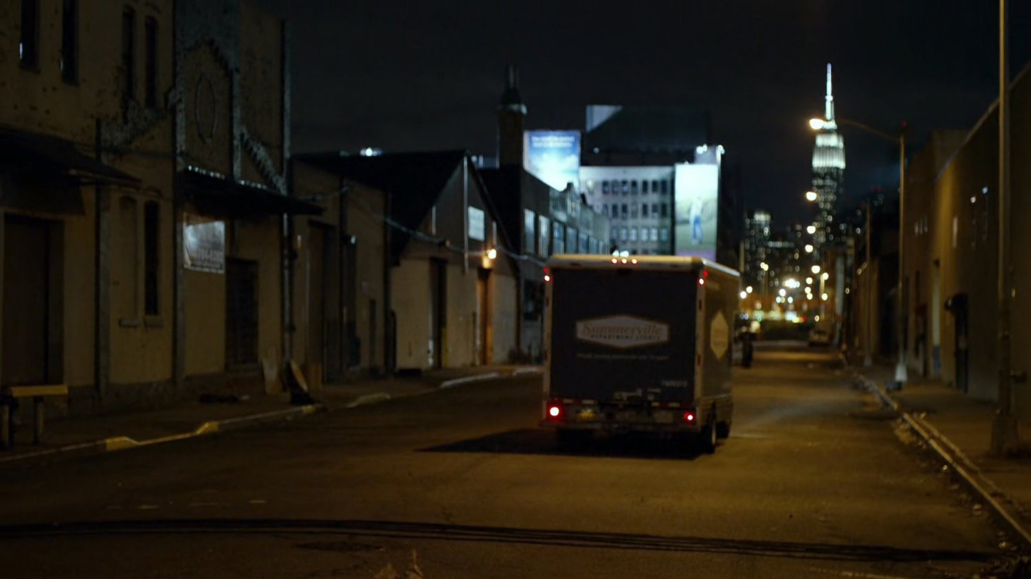 Truck driving along city street.