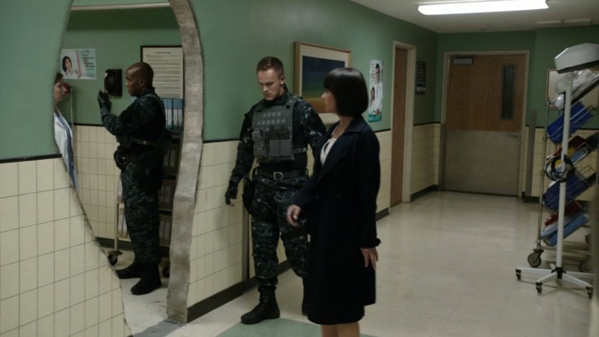 Price looking at hole in hospital hallway wall.