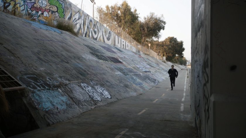Lincoln running along concrete embankment.