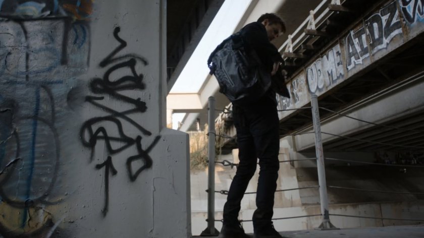 Lincoln standing under two bridges.