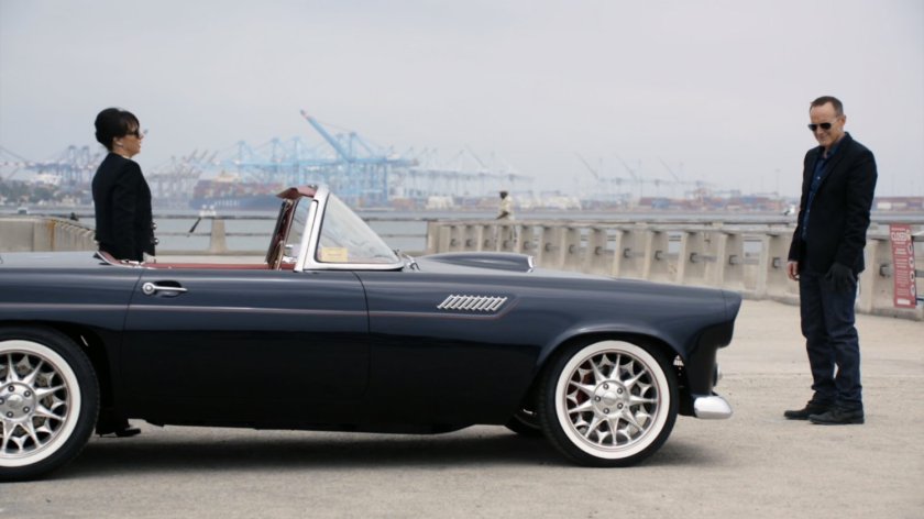 Coulson and Price at a breakwater meeting with cranes in the background.