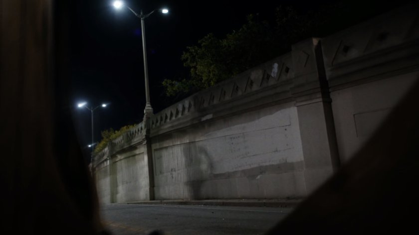 The shadow of Lash morphs along a wall near the van crash.