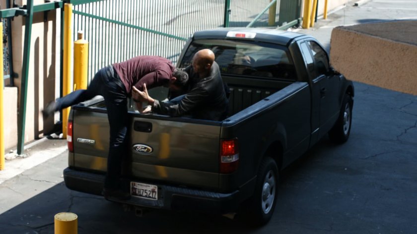 Ward jumps in the back of a pickup truck outside a HYDRA warehouse.