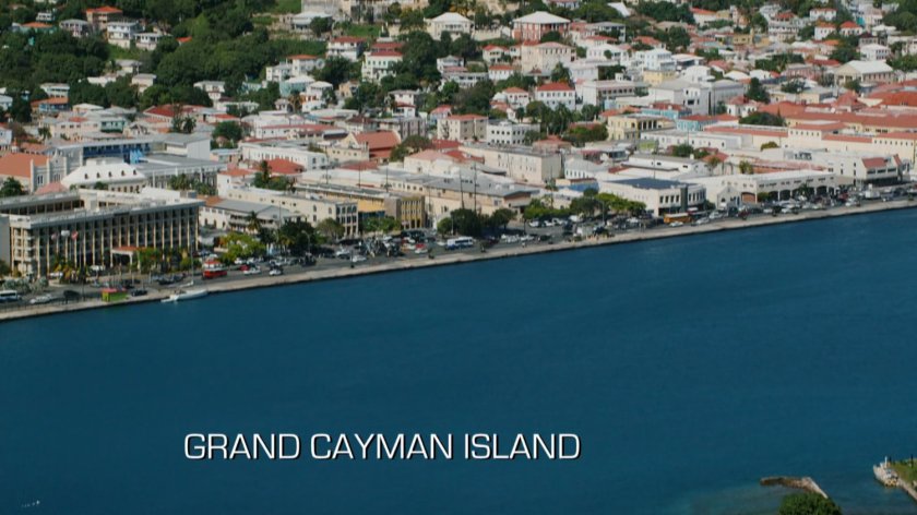 Aerial view of ocean and town. Text: Grand Cayman Island.