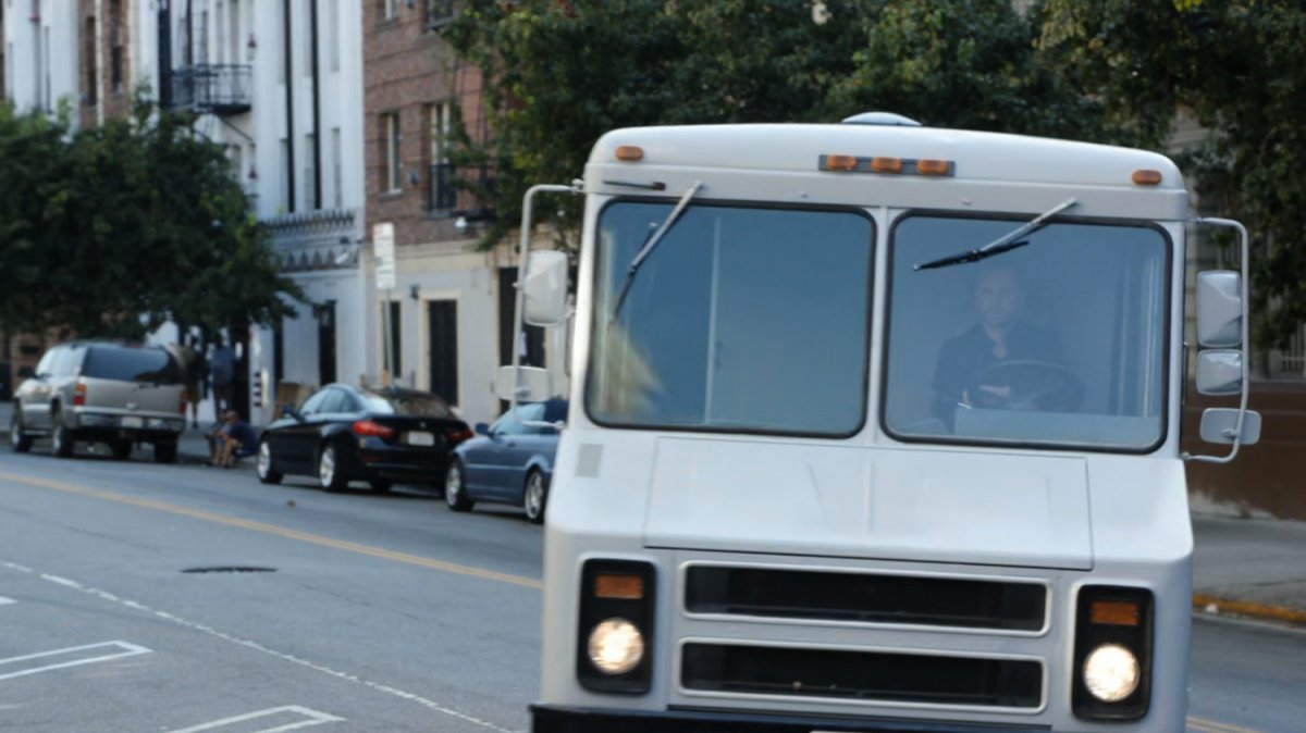 Home theater truck pulling into parking space along Washington DC street.