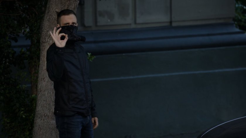 Hunter, wearing a mask, gives the OK sign.