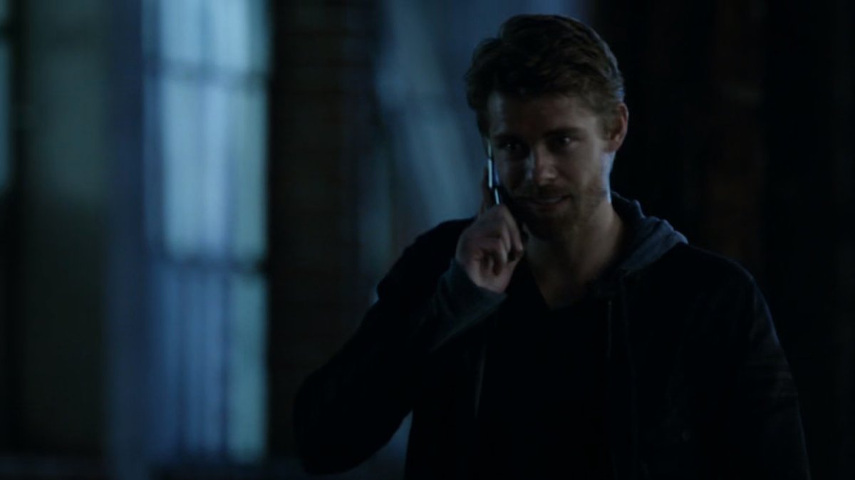 Lincoln on the phone, walking along a dark sidewalk.