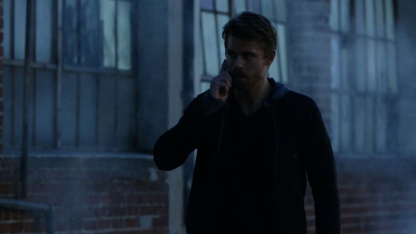 Lincoln on the phone, walking along a dark sidewalk.