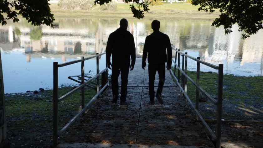 Mack and Lincoln walk on boat launch near lake at a park.