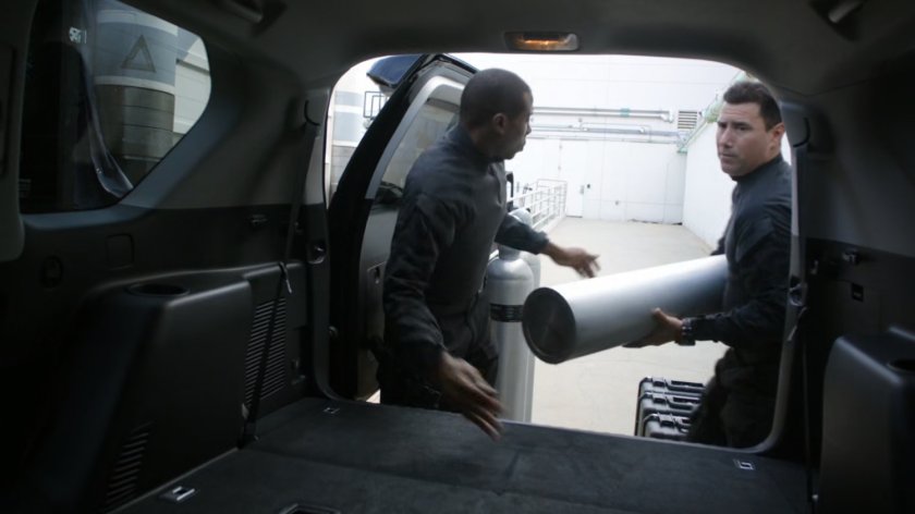 Two men load tanks into an SUV outside a loading dock in Maryland.