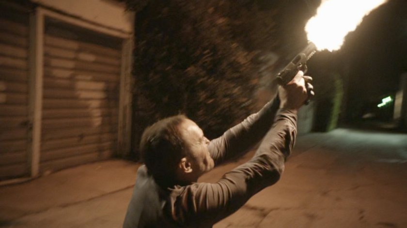 Coulson fires gun toward building from alley behind Washington DC apartment.