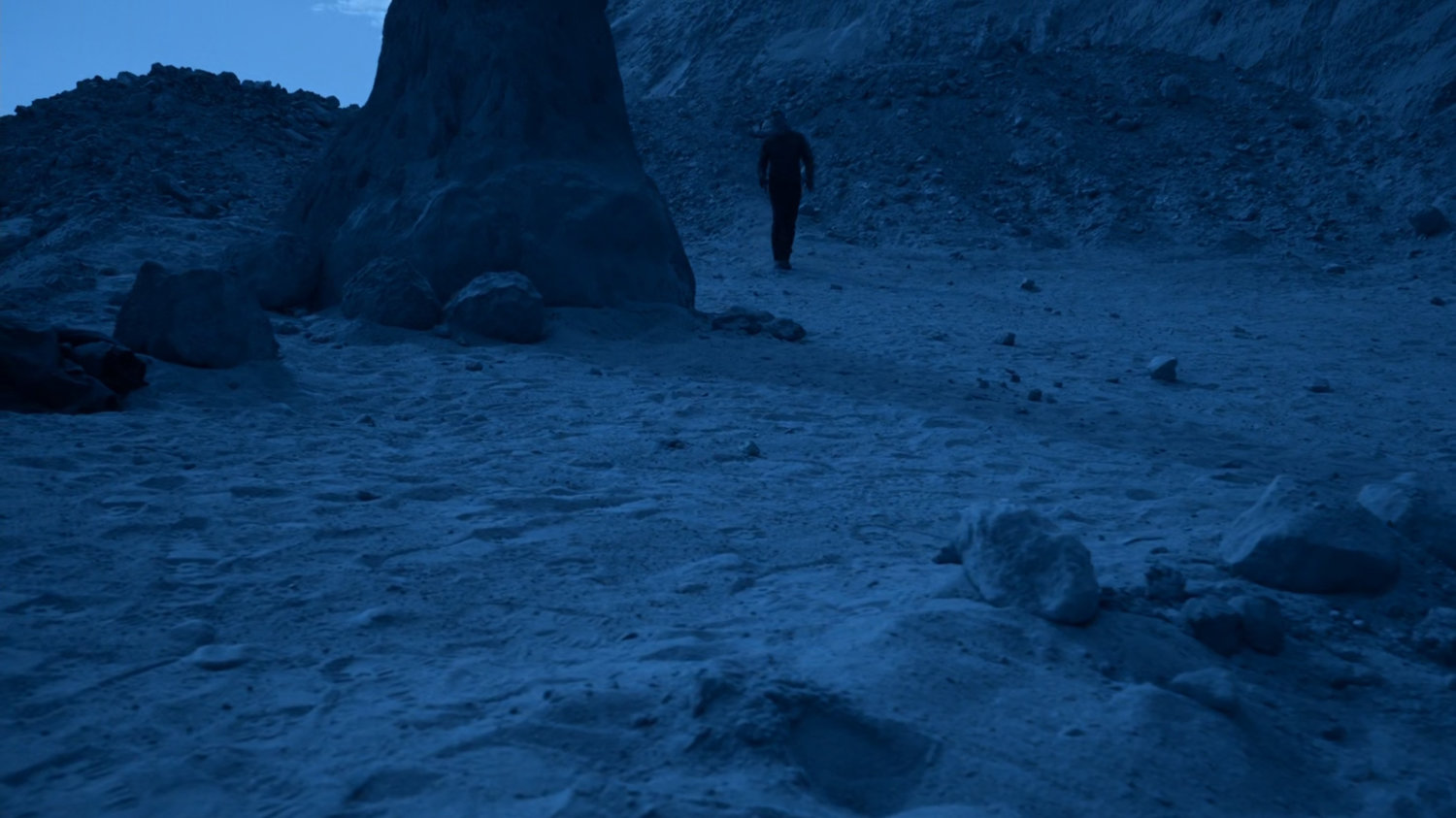 Coulson walking past rock spire on Maveth.