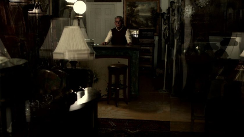 Man behind counter at Monarchy Antiques,