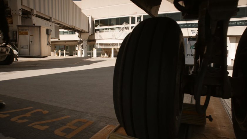View of airport from behind plane tire.
