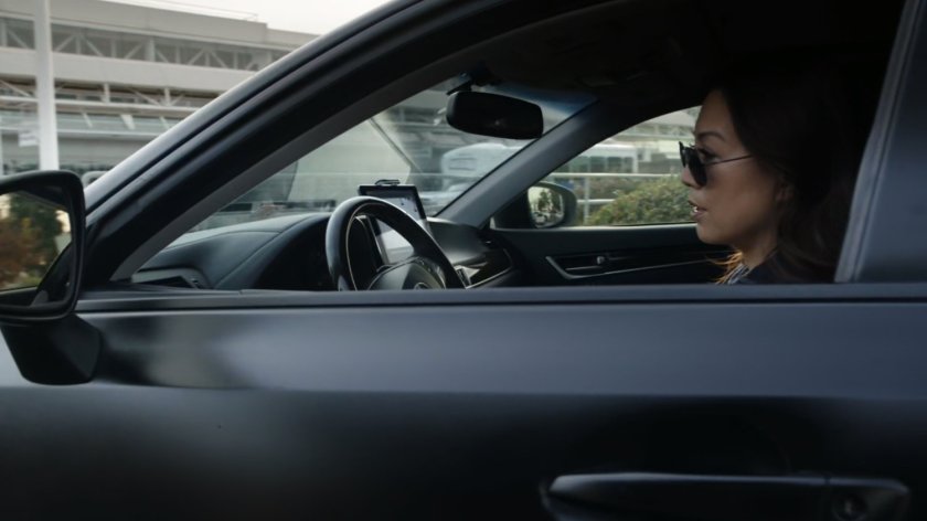 May sitting in car in front of airport.