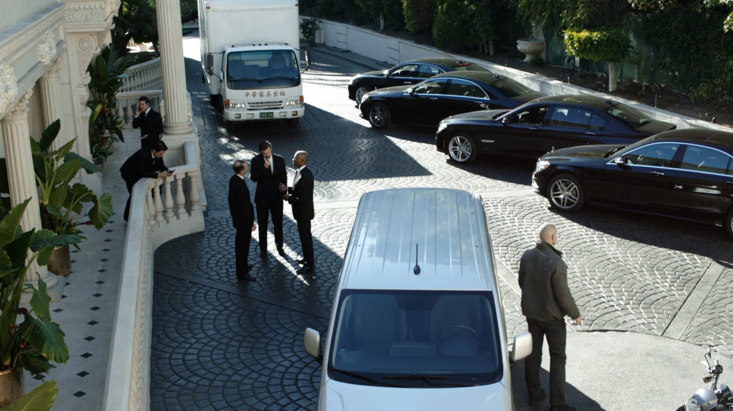 Cars and vans parked outside Taiwanese mansion.
