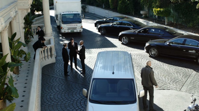 Cars and vans parked outside Taiwanese mansion.