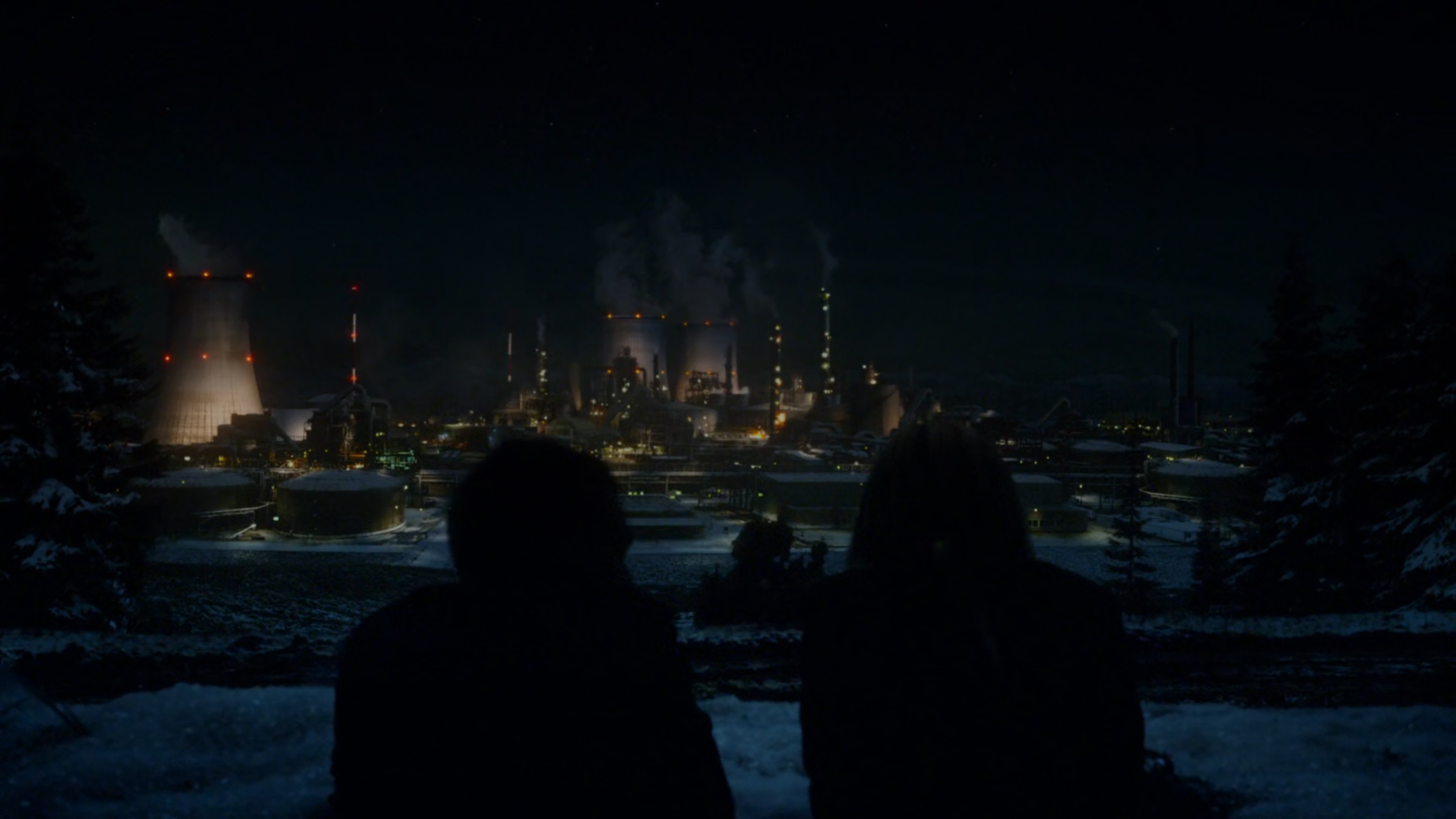 Hunter and Bobbi silhouetted by Russian power plant in distance.