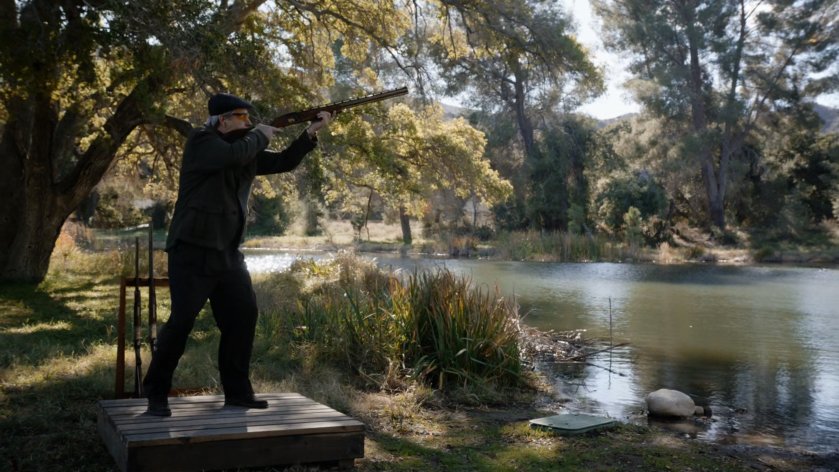 Malick shooting skeet by a lake.