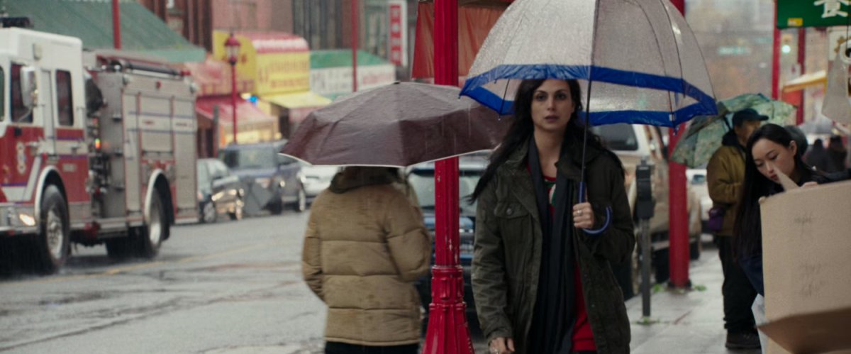 Vanessa walking on sidewalk with an umbrella.