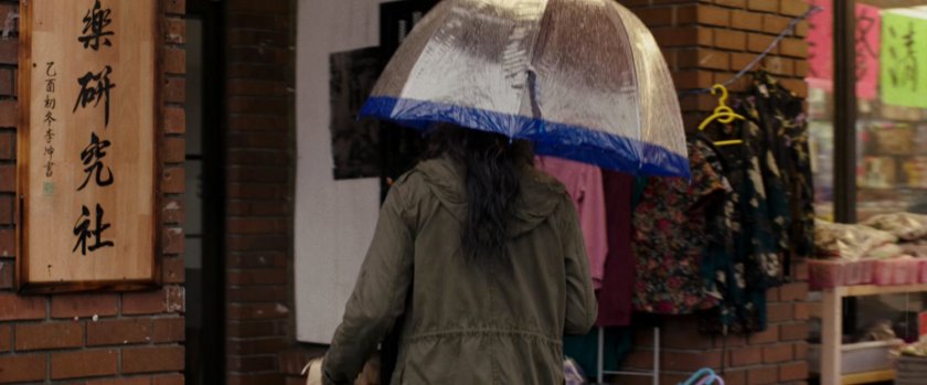 Vanessa enter a building under an umbrella.