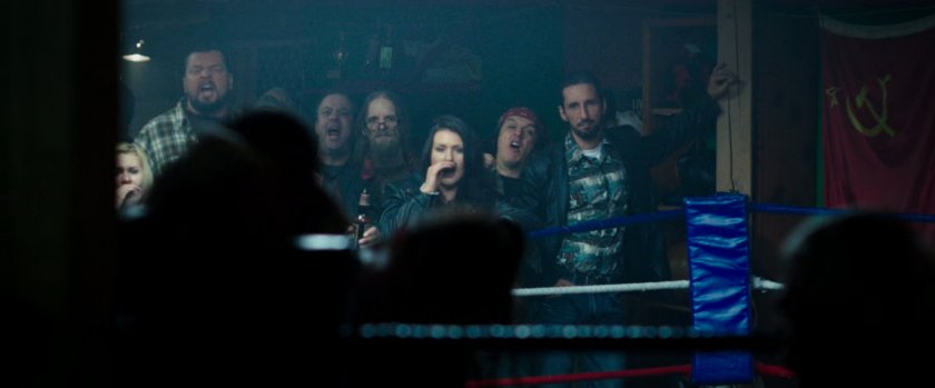 Onlookers shouting at fighters in boxing ring.