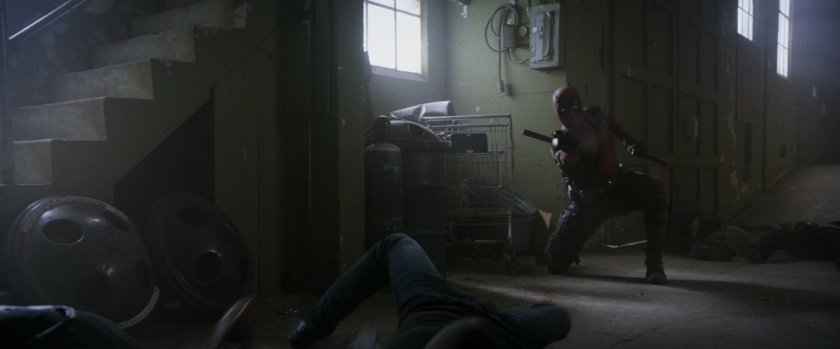 Deadpool kneeling with gun.