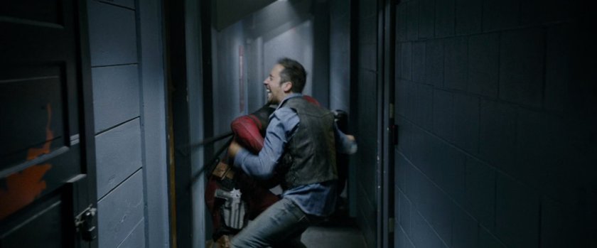 Deadpool beating up men in a hallway.