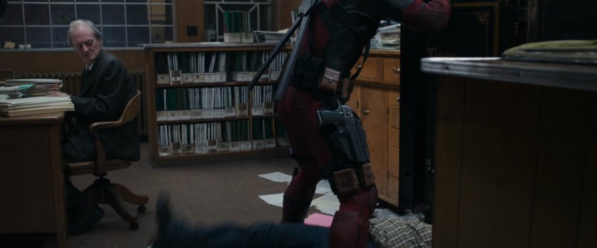 Deadpool beating up man in office.
