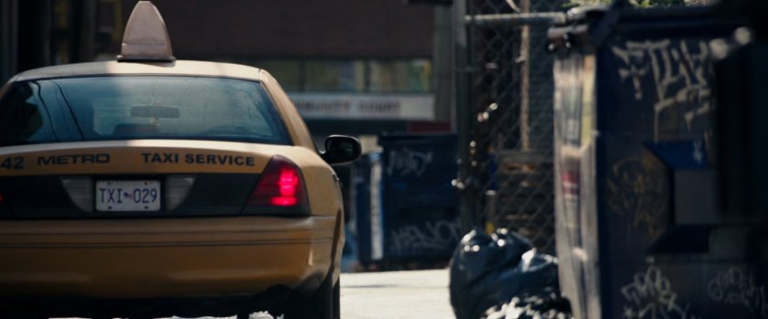 A taxi cab driving through an alley.