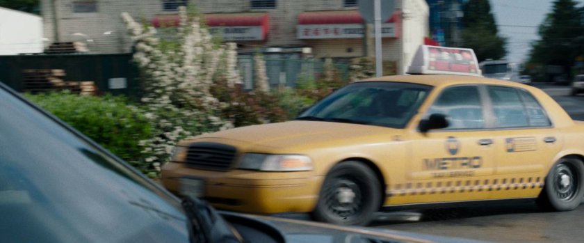 A taxi cab making a right turn at a corner.