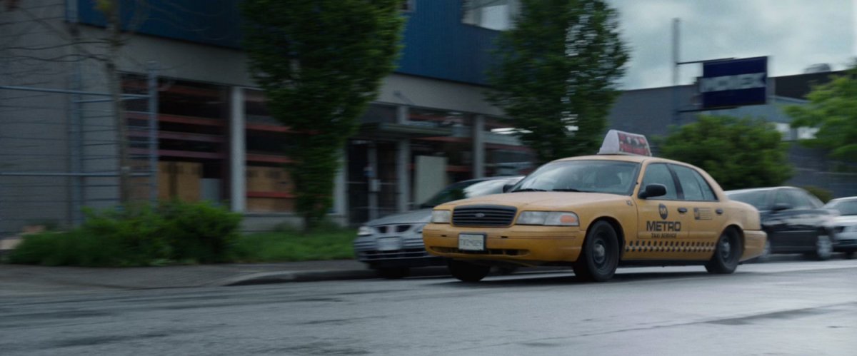 A taxi cab driving along street.