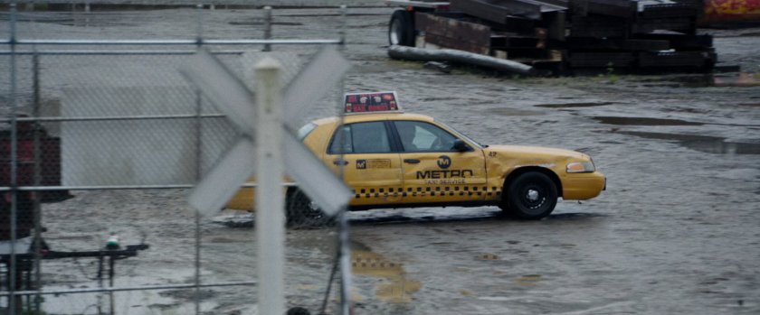 A taxi cab pulling into a scrap yard.