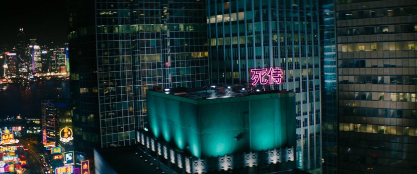 Aerial view of building in Hong Kong with a neon sign on the rooftop.