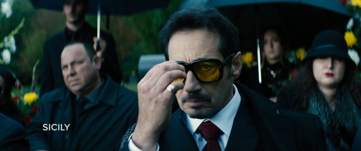 People at a funeral. Text: Sicily.