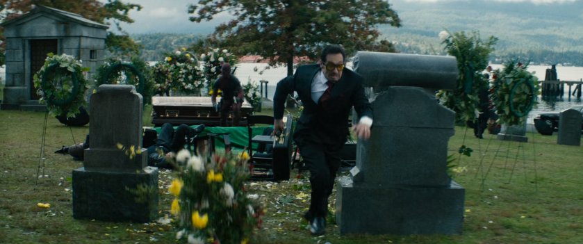 Man running away from Deadpool at a cemetery in Sicily.