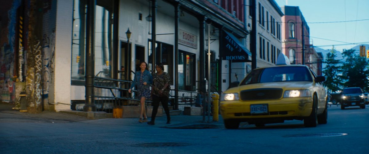 Taxi cab stopped outside street corner.